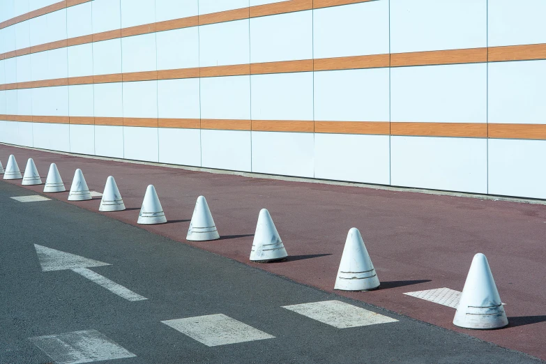 a row of cones is lined up by a building