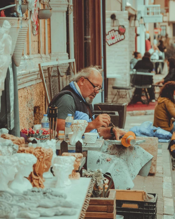 the man is  oranges at the table outside