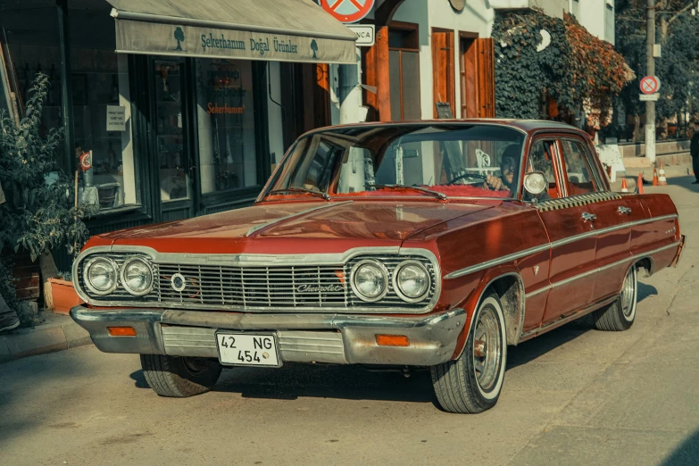 an old red car is parked on a street