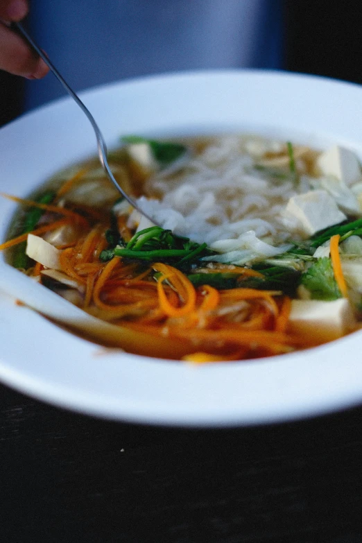 close up view of a white bowl of food with a spoon