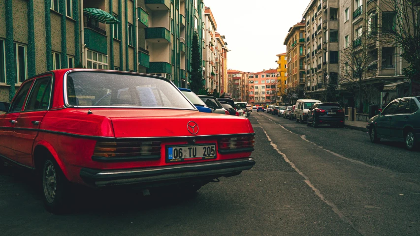 the red car is driving down the street