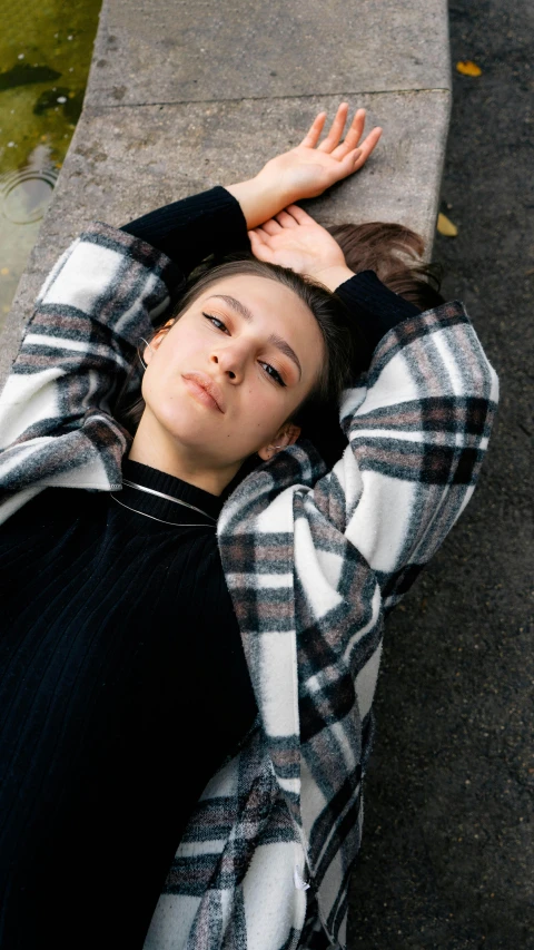 a woman leaning on a bench in the street