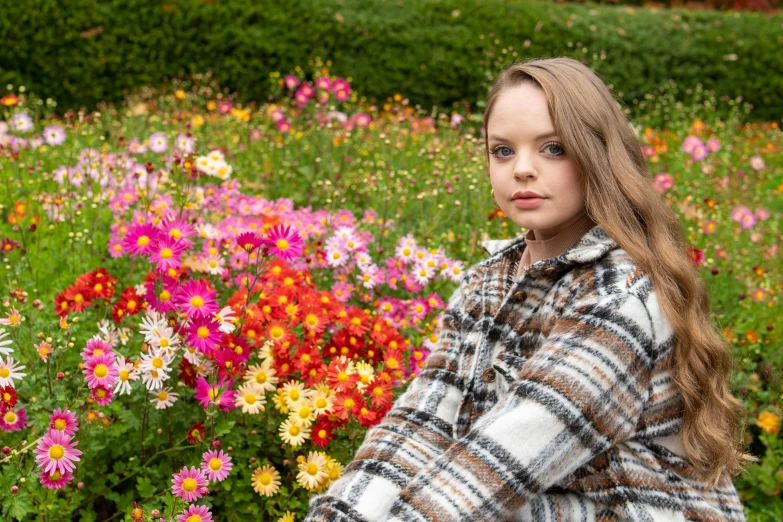 a girl poses for a portrait in a flower field