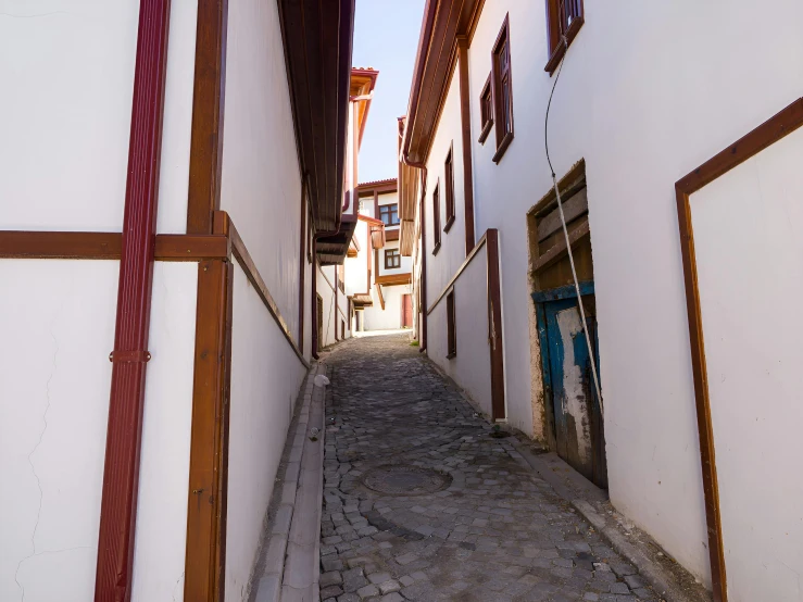 the narrow alley between buildings has windows on either side