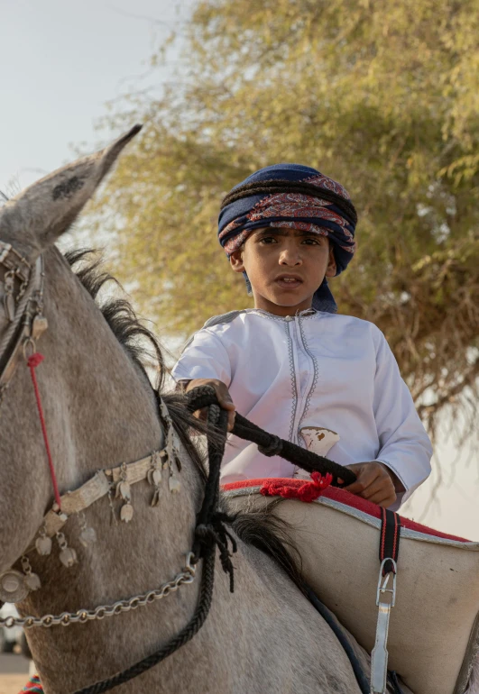 a  riding on the back of a gray horse