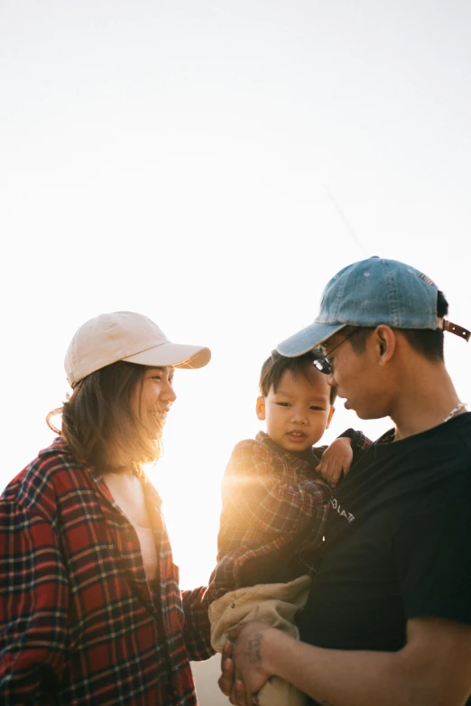 three adults and two children looking at the sky