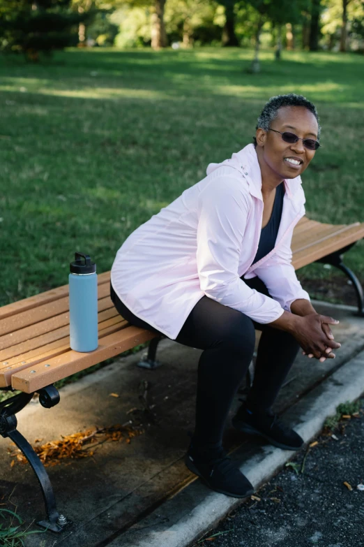 a woman smiles for the camera while sitting on a bench