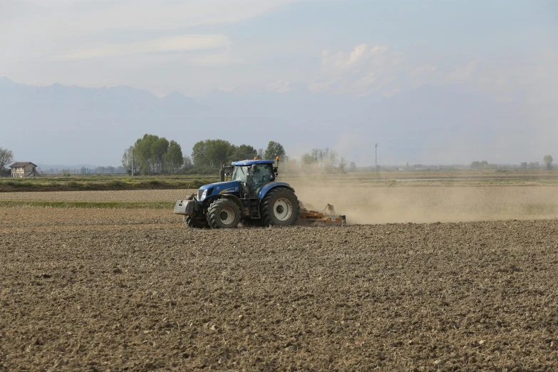 the tractor is digging through a plowed field