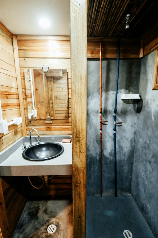 an old rustic bathroom has wood on the walls and floor