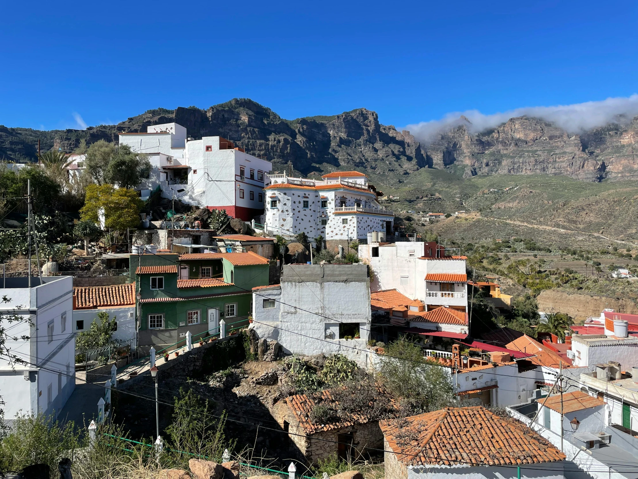 small white houses sit on the hillside of a mountain side village