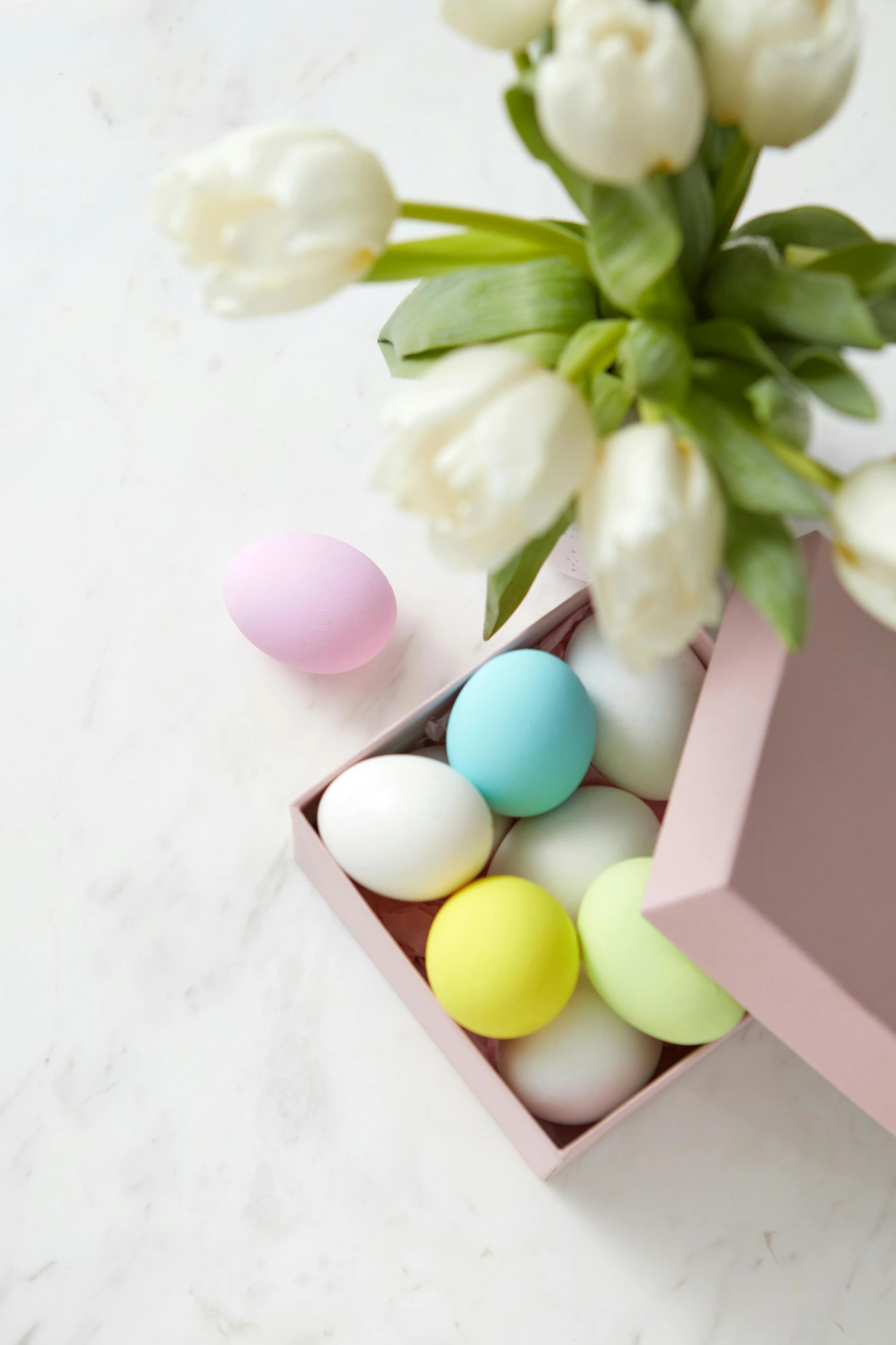 a pink box filled with white and yellow eggs