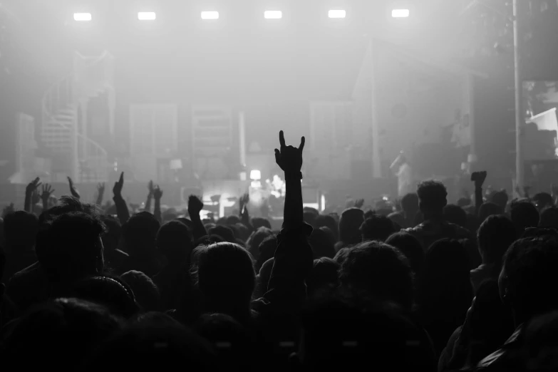 a large crowd is silhouetted by bright lights