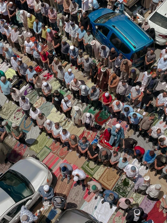 aerial view looking down on an extended outdoor area with many people and cars