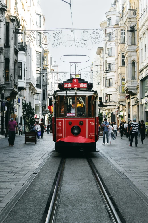 a red trolley car is coming down the tracks