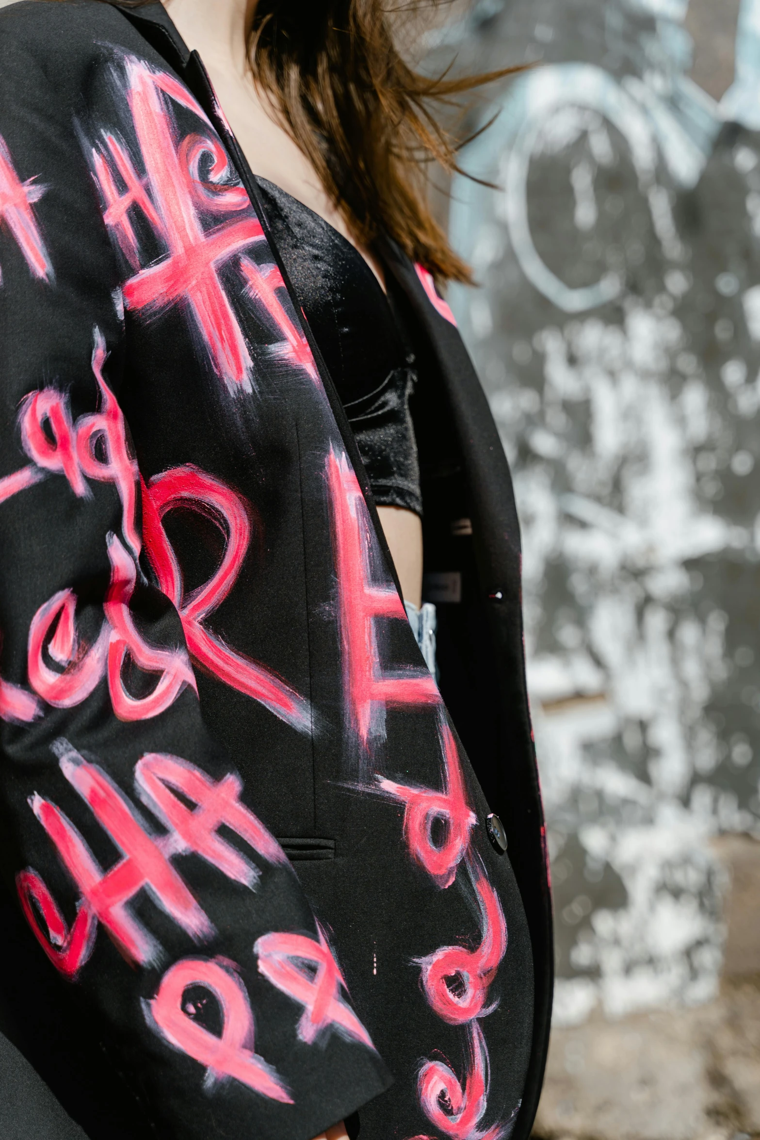 a woman with a black jacket and pink letters on it