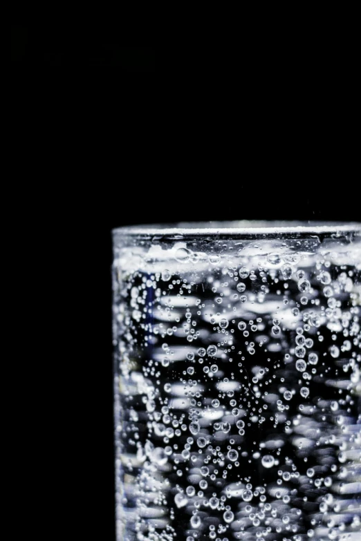 a clear water glass on a dark background