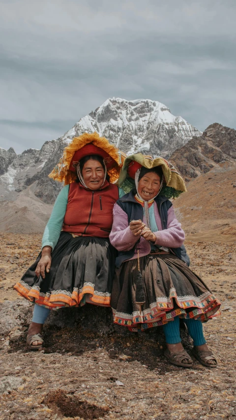 two women in traditional costumes on a dirt ground