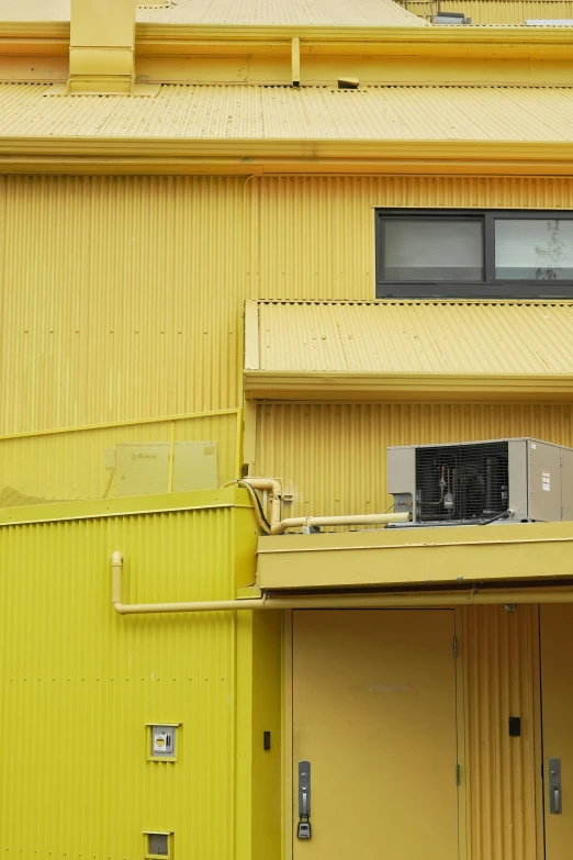 the top part of an industrial building has two garages and is yellow