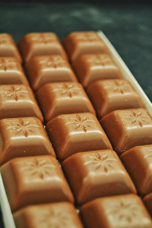 a tray of pieces of chocolate with a flower design