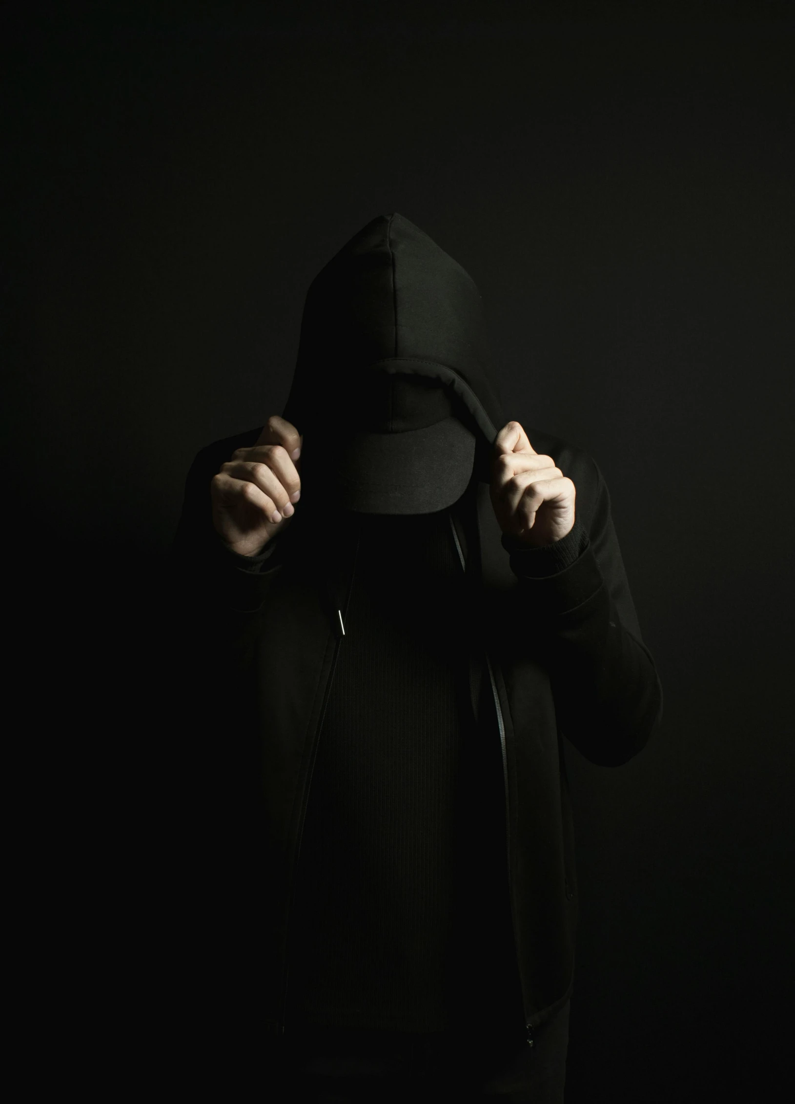 a person wearing a hooded jacket and holding a hat