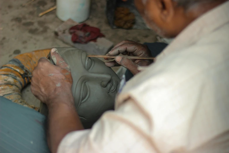 the man in the white shirt is making a pottery vase