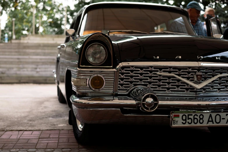 a classic car is sitting in front of some stairs