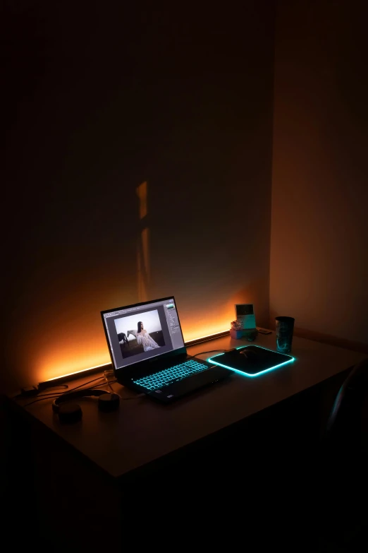 a laptop on a desk with a light coming through the screen