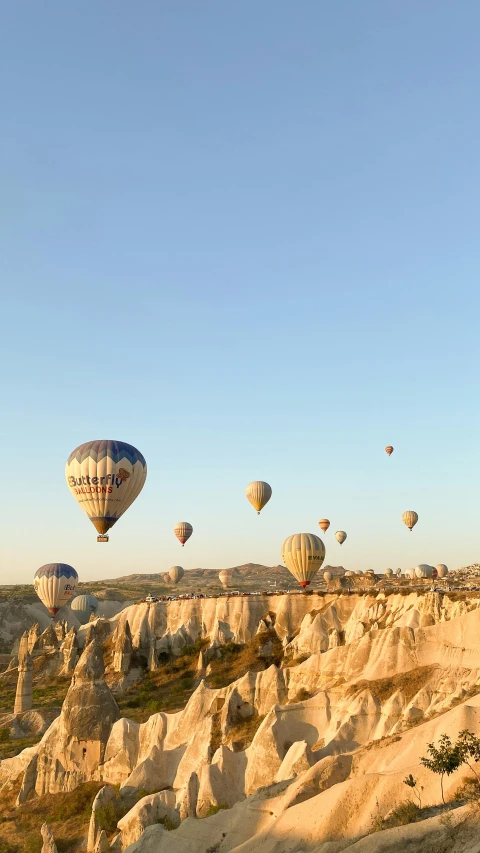 several balloons flying over a mountain top in the sky