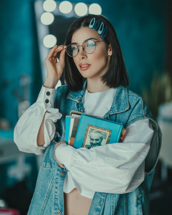 a woman with glasses, a blue jean jacket and some books