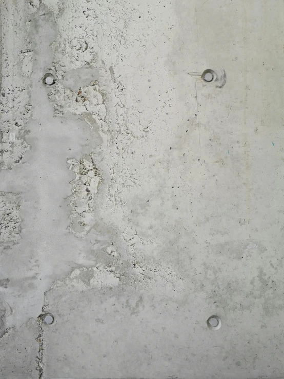 a cement surface with several circles and rivets