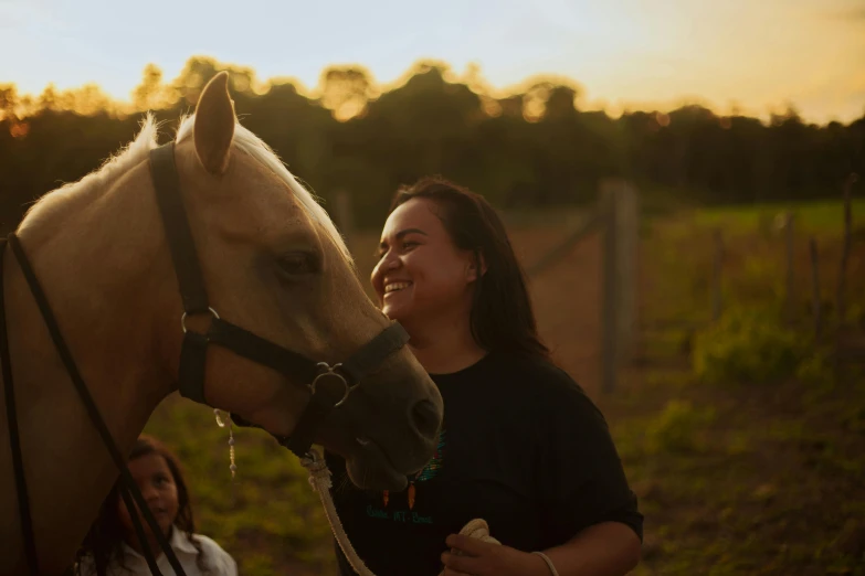 the woman is smiling and petting her horse