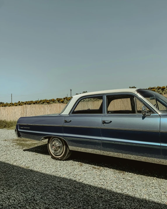 an old, dark car parked on the side of a road