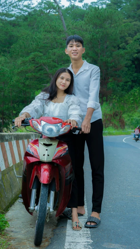 a woman is sitting on a motorcycle next to a man