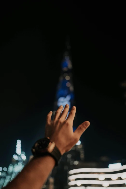 a hand reaching out towards the city skyline