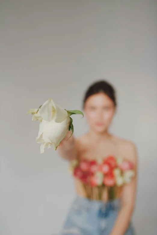 a young lady holding onto a white rose