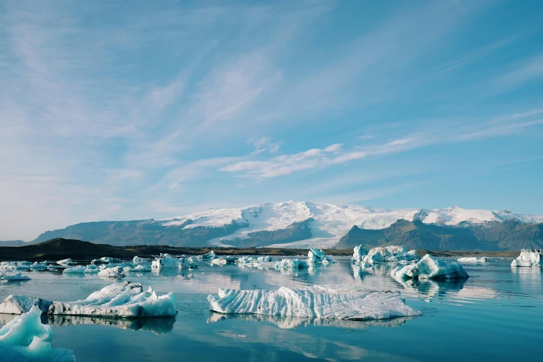 snow covered icebergs floating on the water on a sunny day