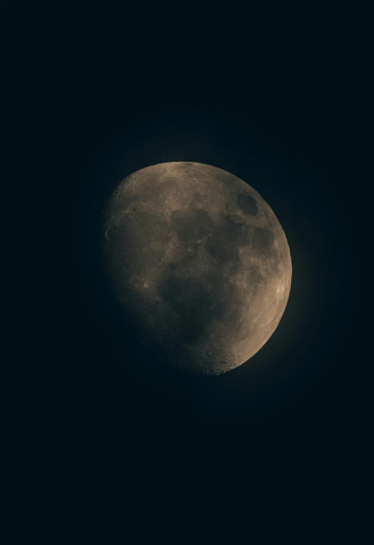 the full moon rises over an area of black sky