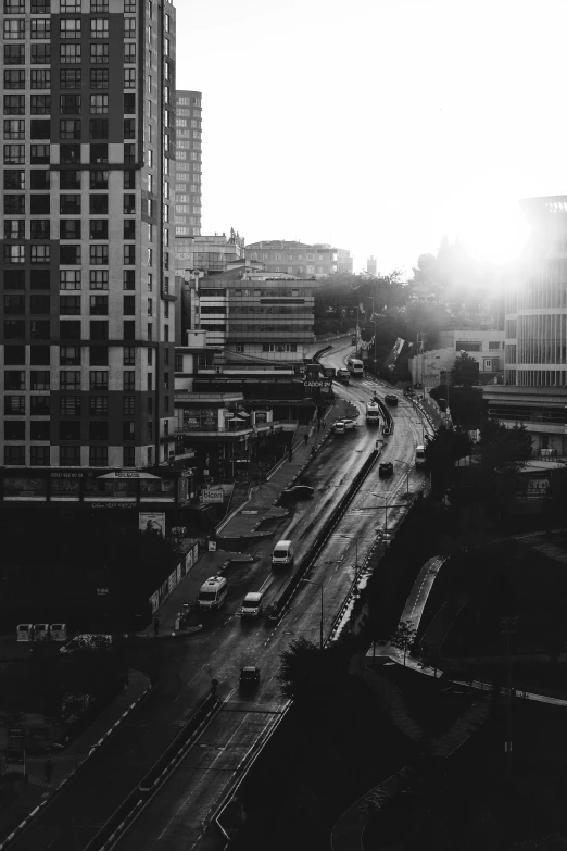 black and white pograph of sun rising on cityscape