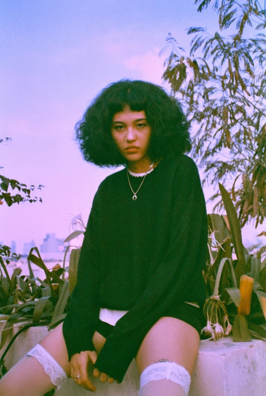 a women who is sitting on the ground wearing knee high shorts