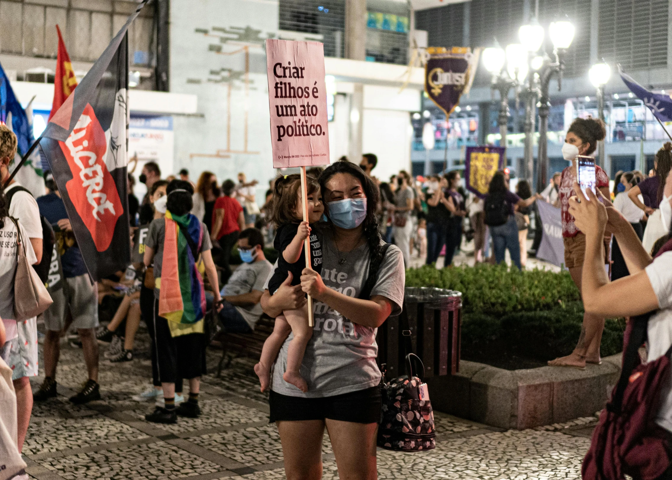 a crowd of people holding signs and standing around each other