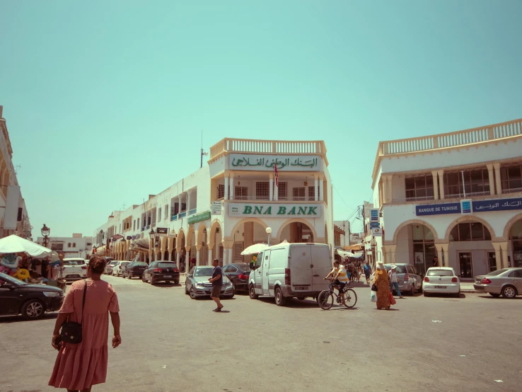 a woman crossing the street in front of shops