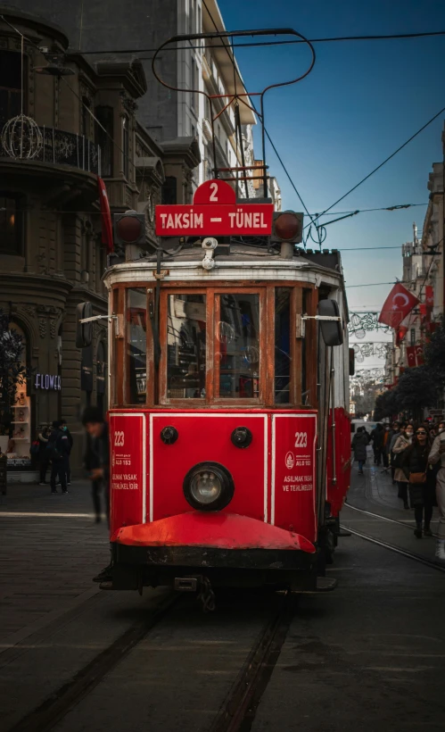 a red and white tram traveling down a street