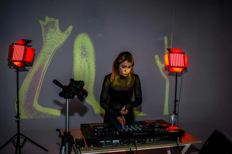 a woman in black shirt playing dj equipment