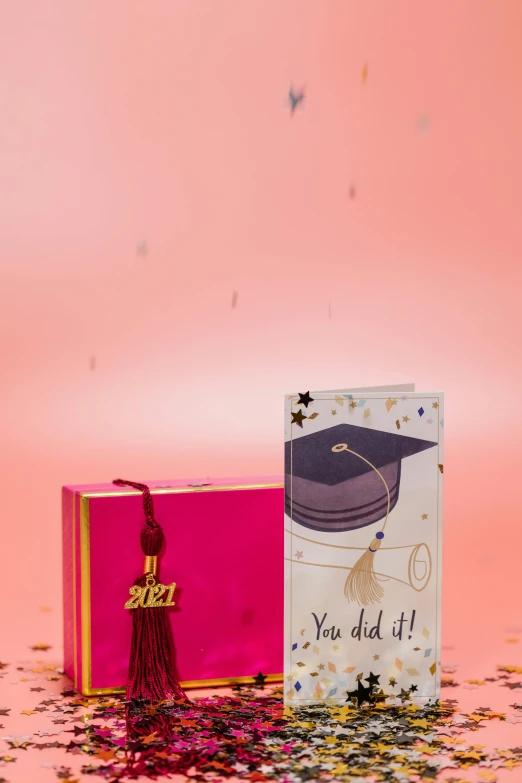 the graduation card is next to the pink box