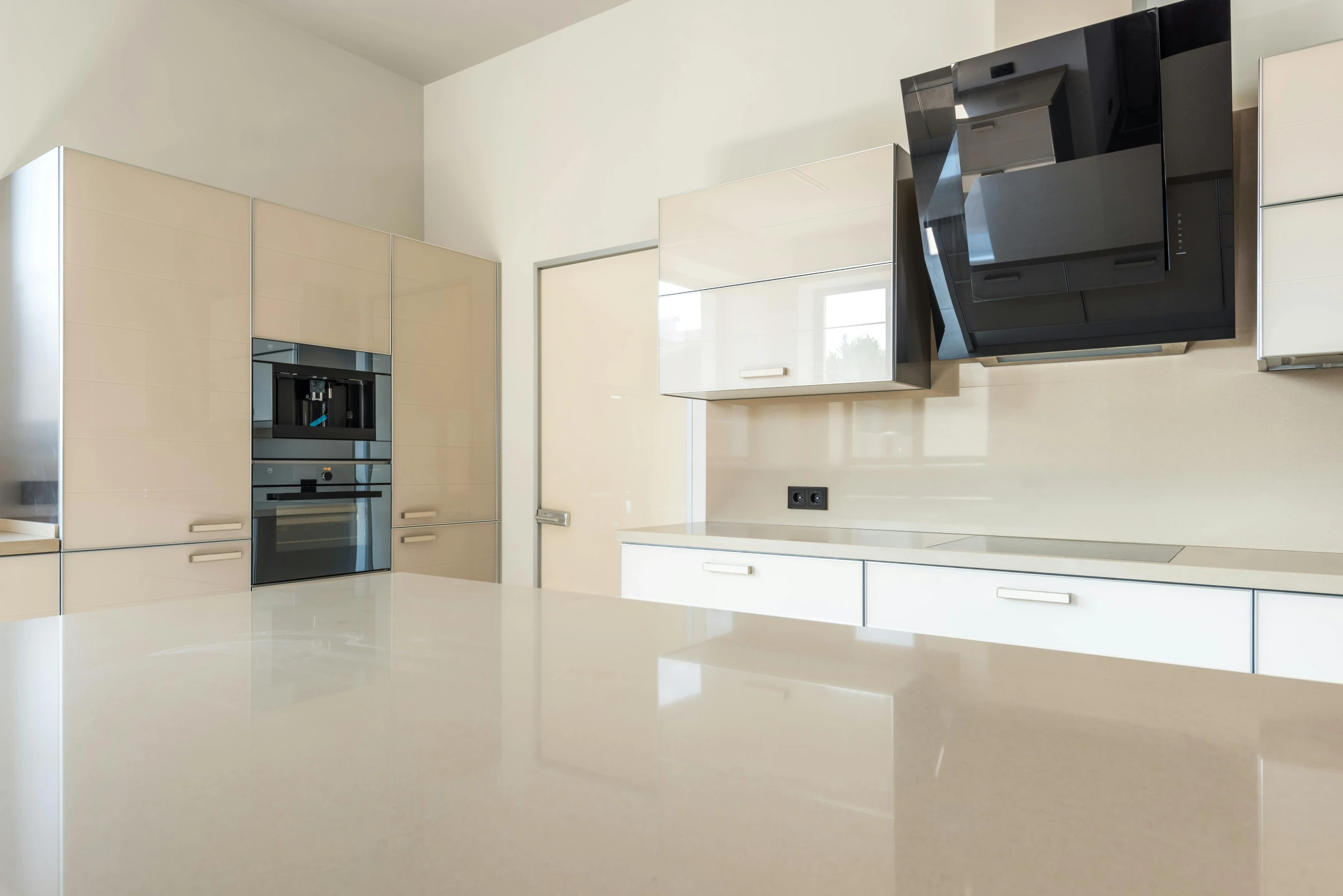 the empty modern kitchen with white cupboards and white marble countertops