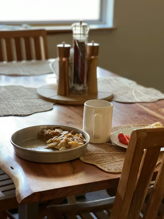 a wooden table topped with a bowl filled with food