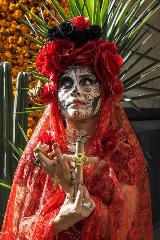 a woman in costume and a face paint holding a flower