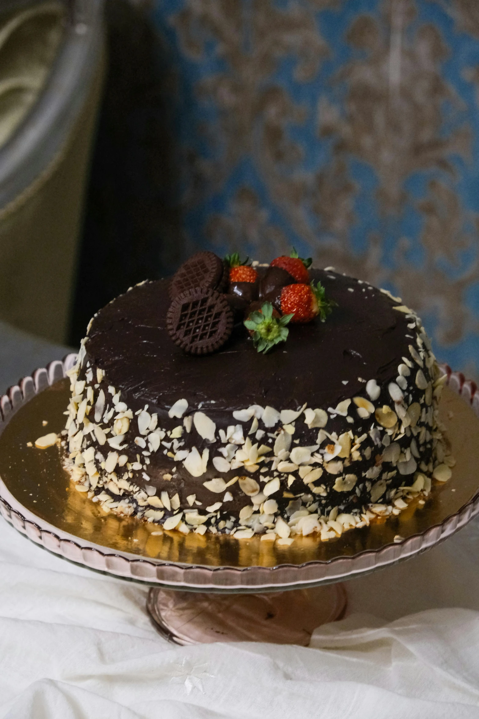 chocolate cake on a silver platter covered in nuts and nuts