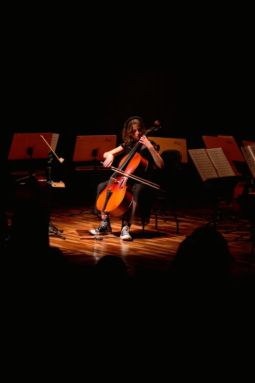 a woman playing a violin while standing on stage