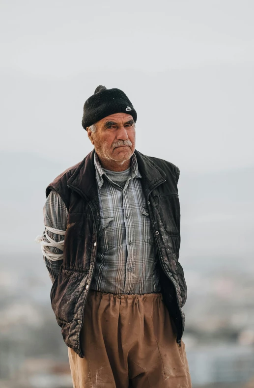 the old man is posing with his hat